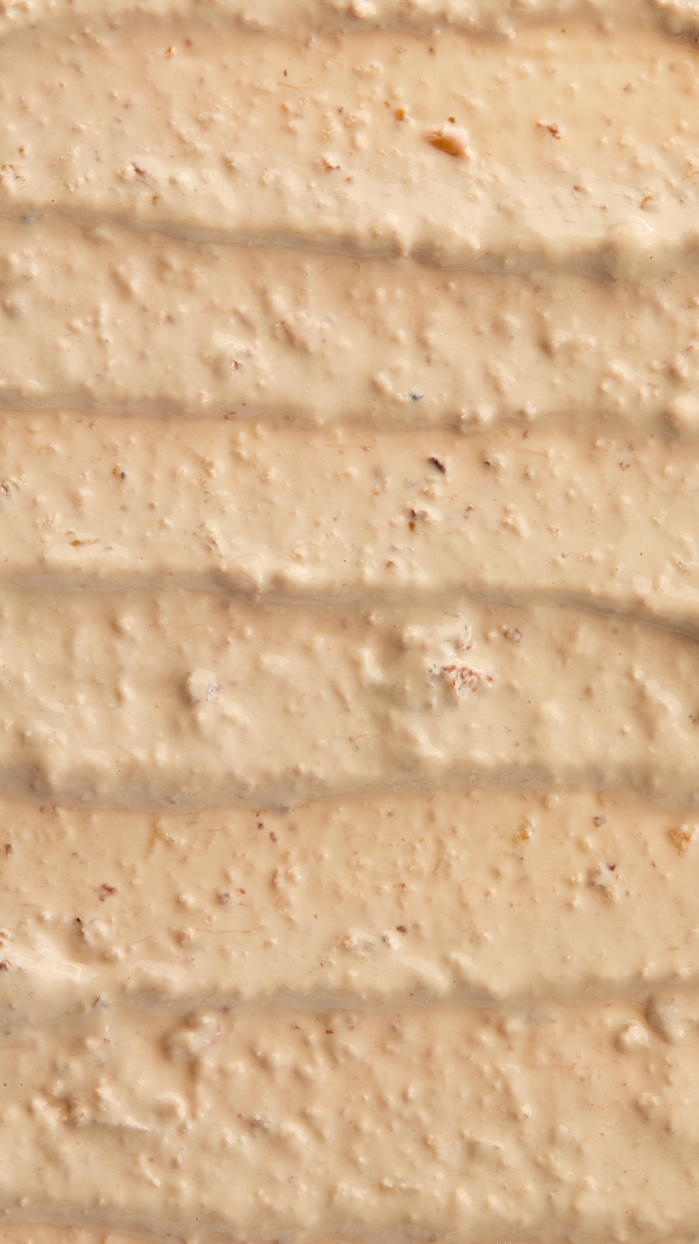 A super close-up image of the creamy, textured Bring Us Some Figgy Pudding face mask product, focusing on the consistency and flecks of finely blended dried figs throughout.