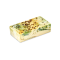 A rectangular bar of Baklava handmade soap with a cream base and marbled swirls of green and gold. The top is sprinkled with dark brown spice seeds, set against a solid black background.