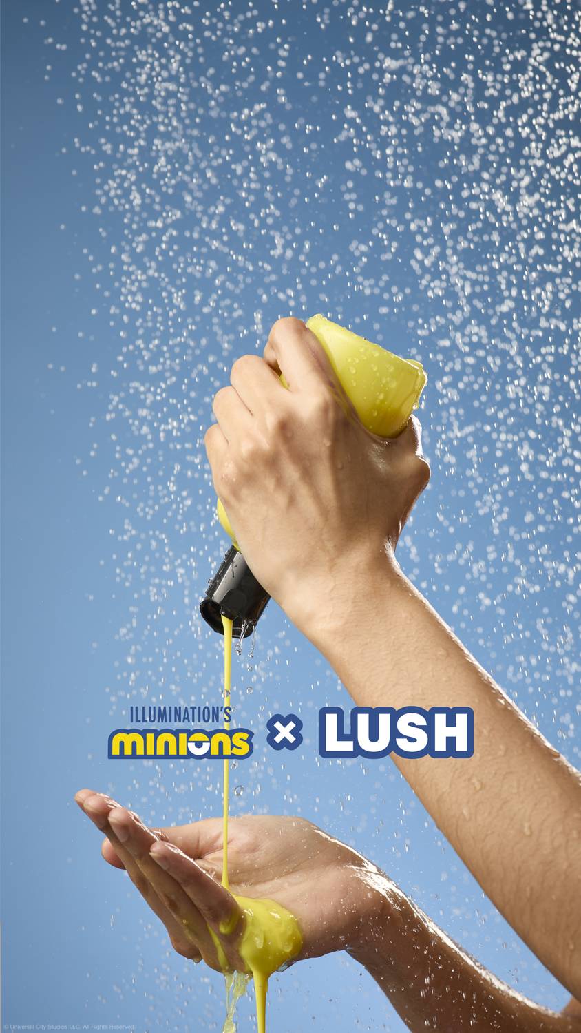 The image shows the model's forearms as they squeeze the bottle of Bananaaa shower cream to catch the yellow product from below. There is running shower water and a pale blue background.