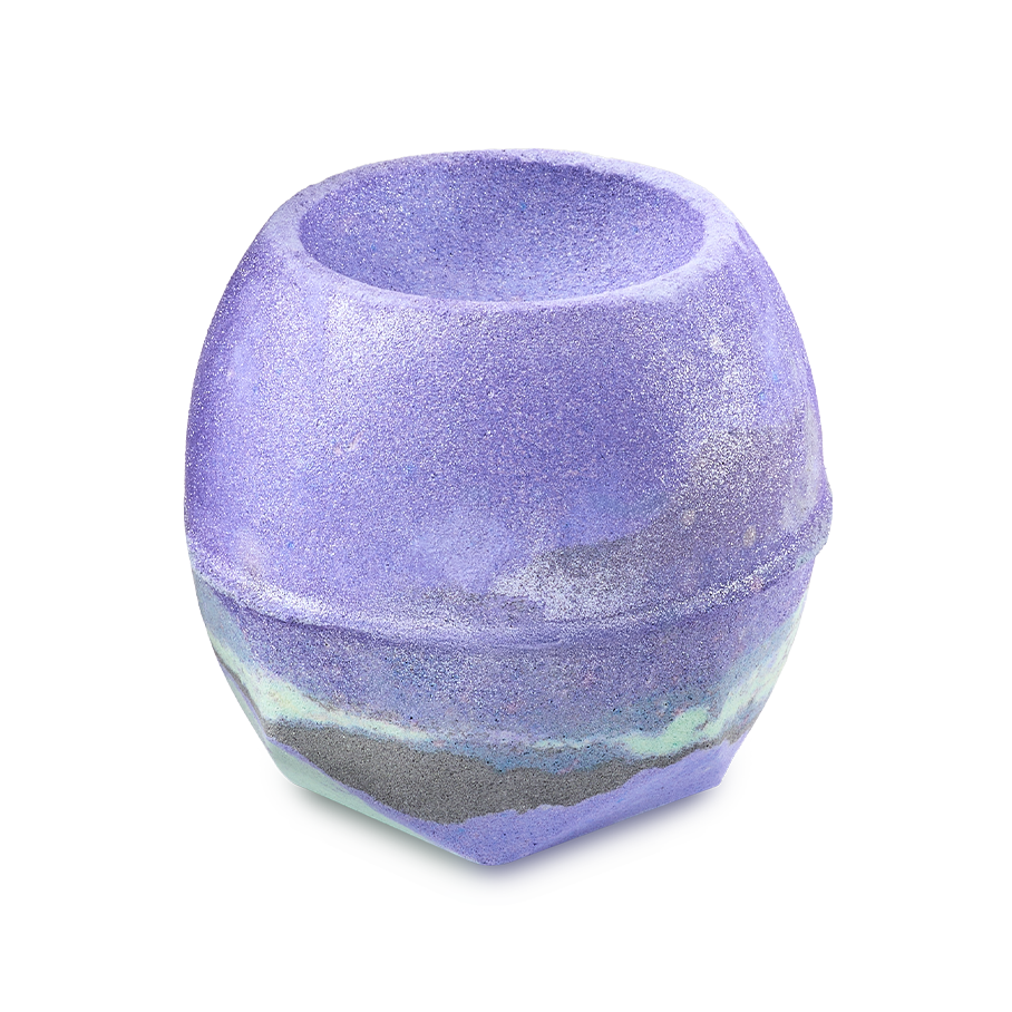 Goddess. A round bath bomb with a bowl-shaped indentation on top. It is primarily vibrant purple with a marbled band of grey and mint green around the base and coated with shimmering silver lustre.