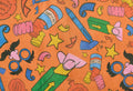 Practical Joker. A rectangular sheet of thick, gift-wrapping paper. The design is a bright orange background with lined, colourful illustrations of accessories associated with impractical jokes such as false gum, can of worms and whoopee cushions.